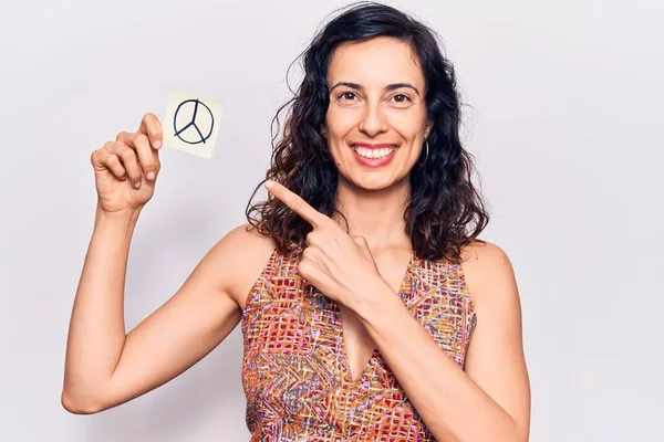 평화를 상징하는 종이를 아름다운 스페인 여자는 손가락으로 행복하게 가리키며 미소짓고 — 스톡 사진