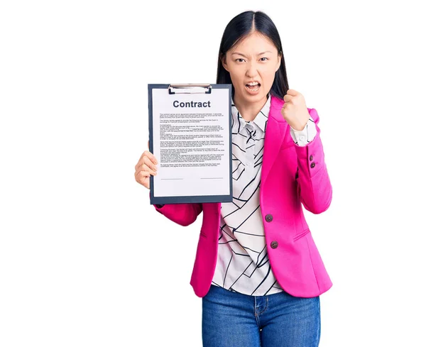 Młoda Piękna Chinka Trzymająca Notatnik Dokumentem Kontraktowym Zirytowana Sfrustrowana Krzykiem — Zdjęcie stockowe