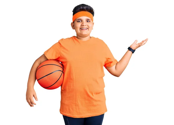 Mały Chłopiec Trzyma Piłkę Koszykówki Świętując Zwycięstwo Szczęśliwym Uśmiechem Ekspresją — Zdjęcie stockowe
