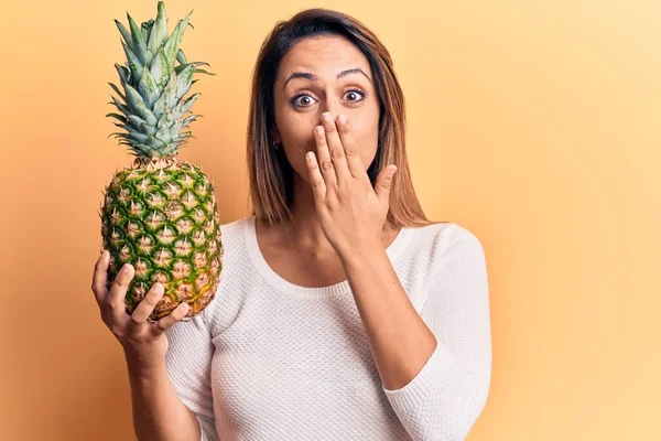 Mladá Krásná Žena Drží Ananas Zakrývající Ústa Rukou Šokovaná Vystrašená — Stock fotografie