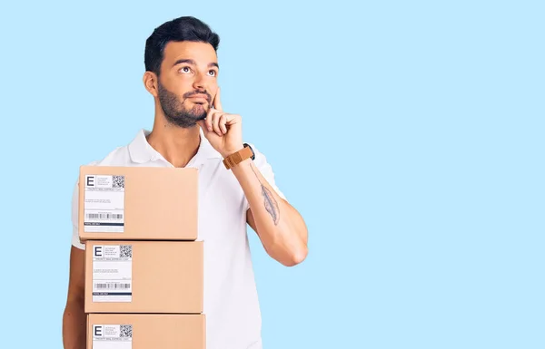 Young Handsome Hispanic Man Holding Delivery Package Serious Face Thinking — Stock Photo, Image