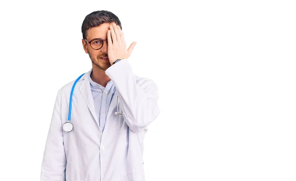 Joven Guapo Con Oso Vistiendo Uniforme Médico Cubriendo Ojo Con —  Fotos de Stock