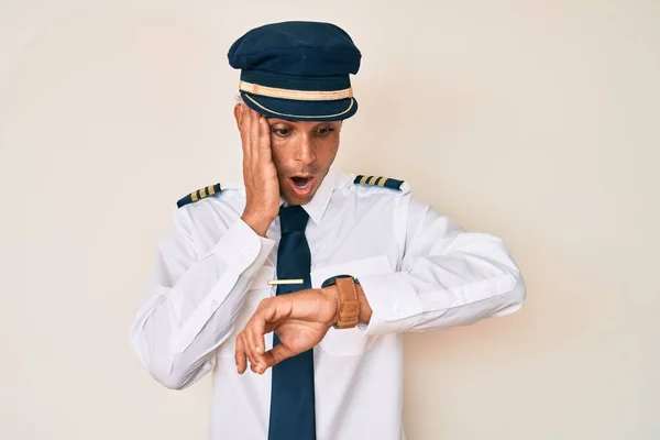 Junger Hispanischer Mann Flugzeugpilotenuniform Schaut Besorgt Auf Die Uhrzeit Hat — Stockfoto