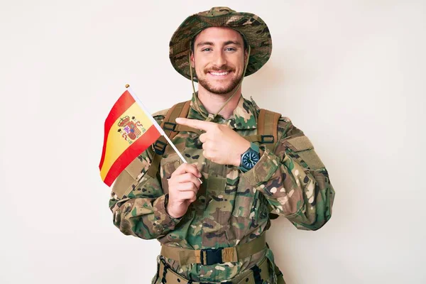 Młody Biały Mężczyzna Mundurze Armii Kamuflażu Trzymając Hiszpańską Flagę Uśmiechając — Zdjęcie stockowe