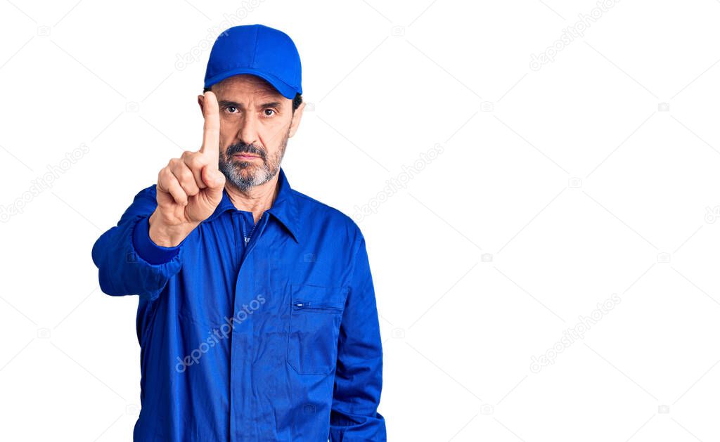 Middle age handsome man wearing mechanic uniform pointing with finger up and angry expression, showing no gesture 