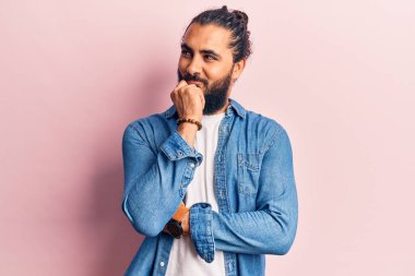 Gündelik giysiler giyen genç bir Arap şüphe üzerine yoğunlaşmıştı. Parmakları çenesinde ve yukarı bakıyordu. 