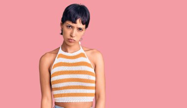 Kısa saçlı, depresif giyinmiş, üzgün ve korkmuş bir şekilde ağlayan esmer bir kadın. hüzünlü ifade. 