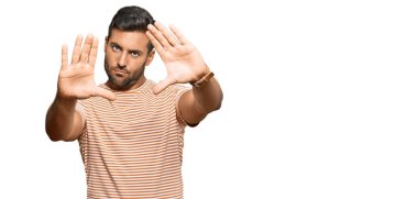 Yakışıklı, günlük kıyafetler giyen, el ve parmaklarıyla çerçeve yapan, kamera bakış açısı olan İspanyol bir adam. 