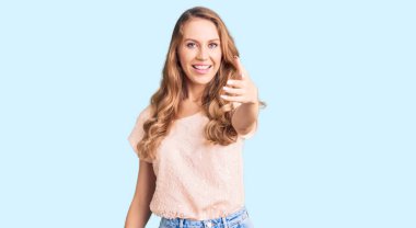 Sarışın, güzel, beyaz bir kadın. Sıradan kıyafetler giyiyor. Arkadaşça gülümsüyor. başarılı iş. 