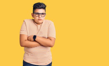 Günlük kıyafetler giyen ve gözlük takan küçük çocuk kış soğuğu için titriyor ve donuyor. Yüzünde üzgün ve şok ifadesi var. 