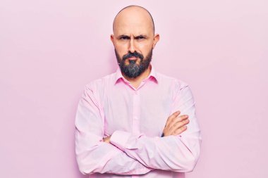 İş kıyafetleri giyen, kuşkucu ve gergin genç bir adam. Yüzünde çapraz kollarla onaylamayan bir ifade var. negatif kişi. 