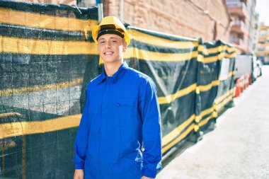 Şehrin caddesinde çalışırken gülümseyen genç İspanyol işçiler