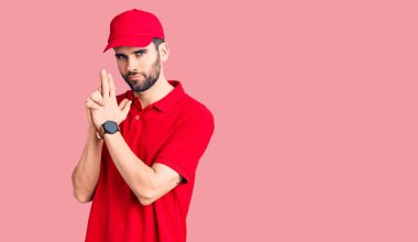 Sakallı, teslimat üniforması giyen, el hareketleriyle sembolik silah tutan, cinayet silahlarıyla oynayan, sinirli yüzlü yakışıklı bir adam. 