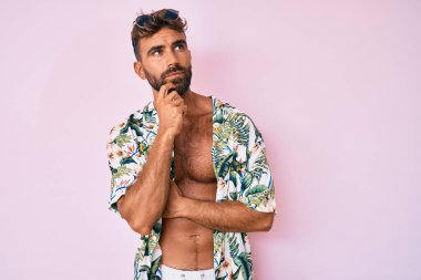 Gündelik yaz kıyafetleri giyen genç İspanyol adam mutlu ve pozitif gülümsüyor, başparmağıyla mükemmel ve onay işareti yapıyor. 