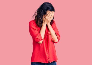 Genç, güzel, İspanyol bir kadın. Günlük kıyafetler giyiyor. Ağlarken suratını ellerle kapatıyor. depresyon kavramı. 