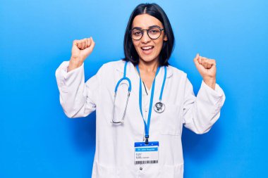 Doktor steteskobu ve kimlik kartı takan genç, güzel Latin kadın gururla bağırıyor, zaferi ve başarıyı kutluyor. 