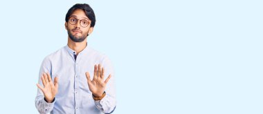 İş gömleği ve gözlük takan yakışıklı İspanyol. Avuçlarını hareket ettiriyor. Korkmuş ve iğrenç bir ifadeyle reddediyor. Dur ve yasakla. 