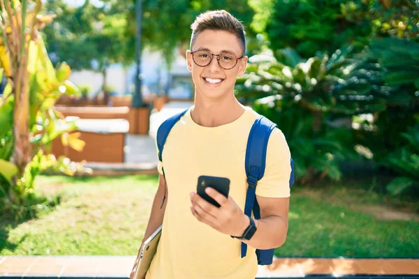 Joven Estudiante Hispano Sonriendo Feliz Usando Smartphone Caminando Por Campus — Foto de Stock