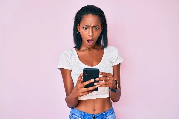 Mujer Afroamericana Joven Usando Teléfono Inteligente Asustado Sorprendido Con Sorpresa —  Fotos de Stock