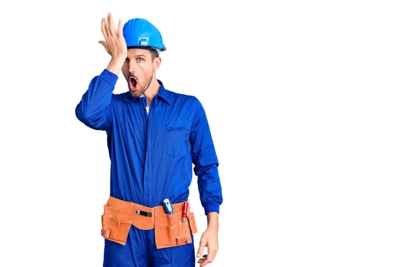 Jovem Homem Bonito Vestindo Uniforme Trabalhador Hardhat Surpreso Com Mão — Fotografia de Stock