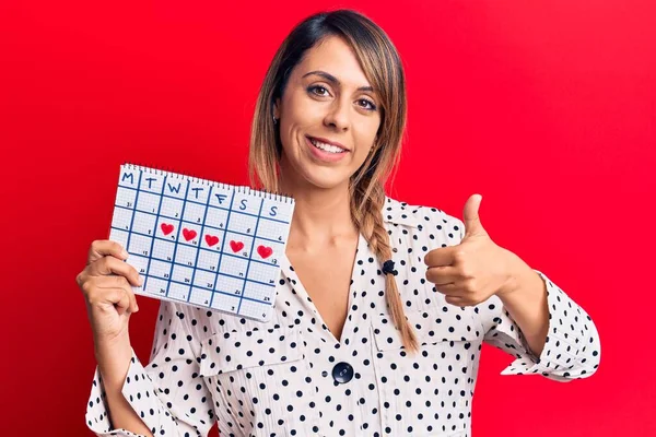 Jovem Bela Mulher Segurando Calendário Período Sorrindo Feliz Positivo Polegar — Fotografia de Stock