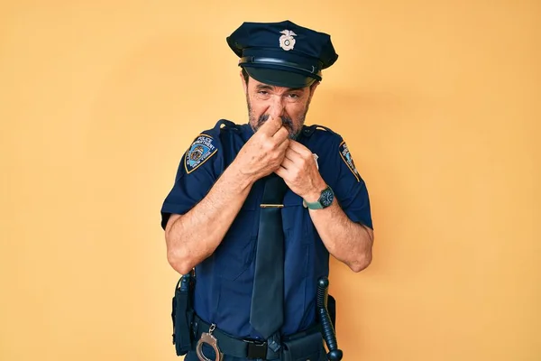 Homem Hispânico Meia Idade Vestindo Uniforme Policial Cheirando Algo Fedorento — Fotografia de Stock