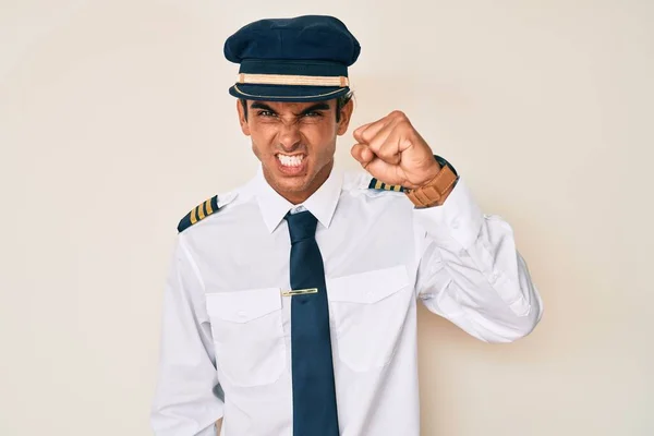 Jovem Hispânico Vestindo Uniforme Piloto Avião Irritado Louco Levantando Punho — Fotografia de Stock
