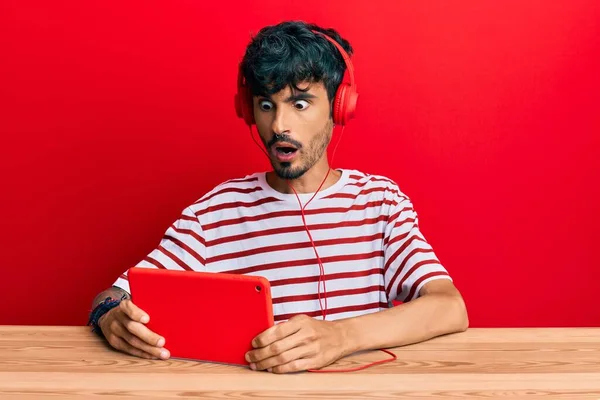 Νεαρός Ισπανόφωνος Χρησιμοποιώντας Touchpad Φορώντας Ακουστικά Φοβισμένος Και Σοκαρισμένος Από — Φωτογραφία Αρχείου