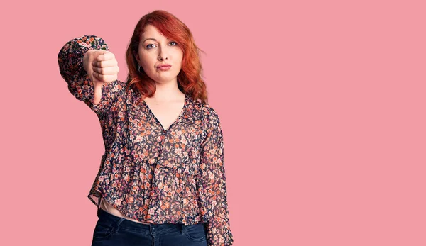 Genç, güzel, kızıl saçlı, gündelik tişört giyen mutsuz, kızgın, reddedilmiş ve olumsuz jestler yapan bir kadın. kötü ifade. 