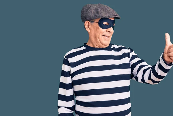 Starší Pohledný Muž Maskou Lupiče Tričkem Hrdě Usmívající Ukazující Palcem — Stock fotografie