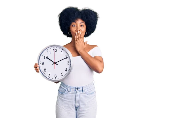 Joven Afroamericana Americana Sosteniendo Gran Reloj Cubriendo Boca Con Mano —  Fotos de Stock