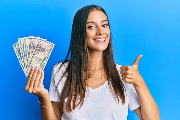 Mujer Hispana Joven Sosteniendo Dólares Sonriendo Feliz Positivo Pulgar Hacia — Foto de Stock