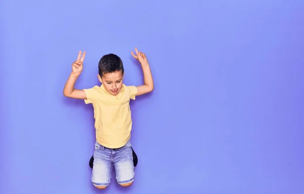 Adorabile Bambino Che Indossa Vestiti Casual Saltando Sfondo Viola Isolato — Foto Stock