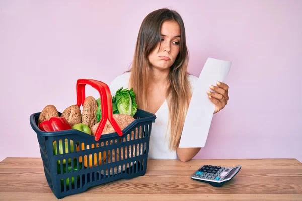 Beautiful Caucasian Woman Holding Supermarket Basket Groceries List Depressed Worry — Stock Photo, Image