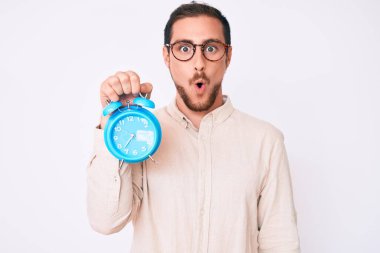 Çalar saati tutan yakışıklı genç adam şaşıracak bir ağızla korkmuş ve hayrete düşmüştü. 