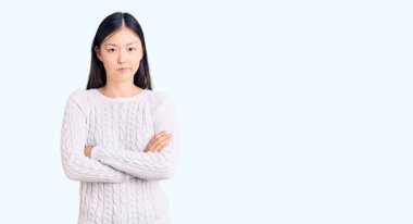 Genç, güzel, Çinli bir kadın sıradan bir süveter giyiyor. Kuşkucu ve gergin. Yüzünde çapraz kollarla onaylamayan bir ifade var. negatif kişi. 