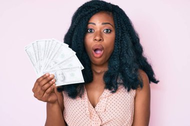 Dolarları tutan güzel Afrikalı bir kadın. Korkmuş ve ağzı açık kalmış, şaşırmış, inançsız bir yüz. 