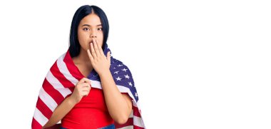 Amerika Birleşik Devletleri bayrağını tutan genç, güzel Asyalı kız ağızlarını eliyle kapatıyor, şok geçiriyor ve hata yapmaktan korkuyor. şaşırmış ifade 