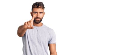 Latin asıllı genç bir adam, gündelik giysiler giyip parmağını kaldırmış ve kızgın bir ifade takınıyor. 
