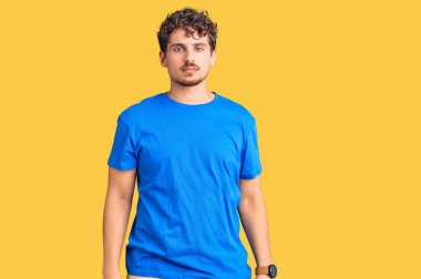 Kıvırcık saçlı, uykulu ve yorgun görünen, akşamdan kalma ve yorgun, tembel gözlü genç yakışıklı bir adam.. 