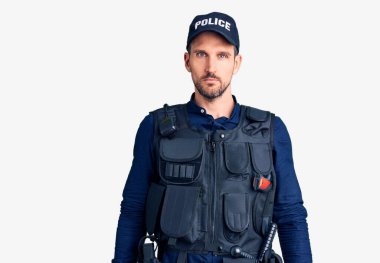 Polis üniforması giyen yakışıklı genç adam yüzünde ciddi bir ifadeyle rahatlamış. Basit ve doğal bir şekilde kameraya bakıyorsun.. 