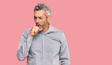 Orta yaşlı, gri saçlı, günlük kıyafetler giyen, kendini kötü hisseden ve soğuk algınlığı veya bronşitin belirtisi olarak öksüren bir adam. sağlık hizmeti kavramı. 