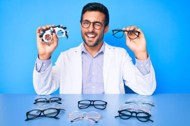 Optometri gözlüklü genç İspanyol adam kameraya seksi bir ifadeyle bakıyor, neşeli ve mutlu bir yüzle.. 