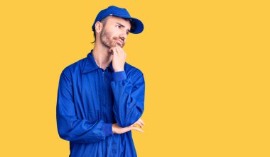 İspanyol ressam üniforması giyen genç bir adam ciddi bir yüz ifadesi, eli çenesinde soru soran, kafa karıştırıcı bir fikir hakkında düşünceli. 