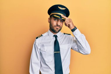 Alnındaki sivilceden mutsuz olan, siyah noktalı çirkin enfeksiyonu gösteren, uçak pilotu üniforması giyen yakışıklı bir İspanyol. sivilce ve deri problemi 