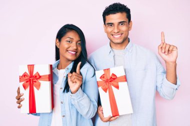 Güzel Latin bir çiftin yıldönümü kutlaması için hediye tutması bir fikir ya da soru işareti ile şaşırttı. 