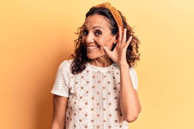 Orta yaşlı, güzel bir kadın. Günlük tişört giyiyor. Kulağı kulağında gülümsüyor, dedikodu ya da dedikoduları dinliyor. Sağırlık kavramı. 