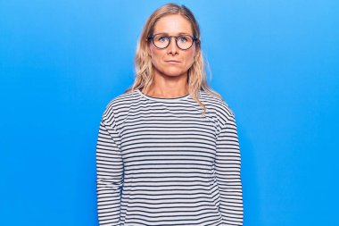 Orta yaşlı, beyaz, çizgili süveter giyen, gözlüklü, sinirli ve korkmuş bir kadın. hüzünlü ifade. 