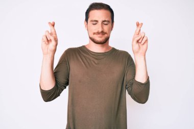 Sıradan kıyafetler giyen genç yakışıklı adam umut ve gözlerin kapalı gülümseyerek el sallıyor. Şans ve batıl inançlar. 