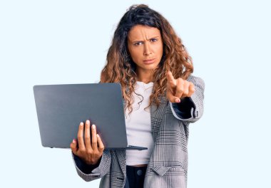 Elinde dizüstü bilgisayarı olan genç İspanyol bir kadın kamerayı işaret ediyor ve sen kendine güvenen ciddi bir hareket yapıyorsun. 